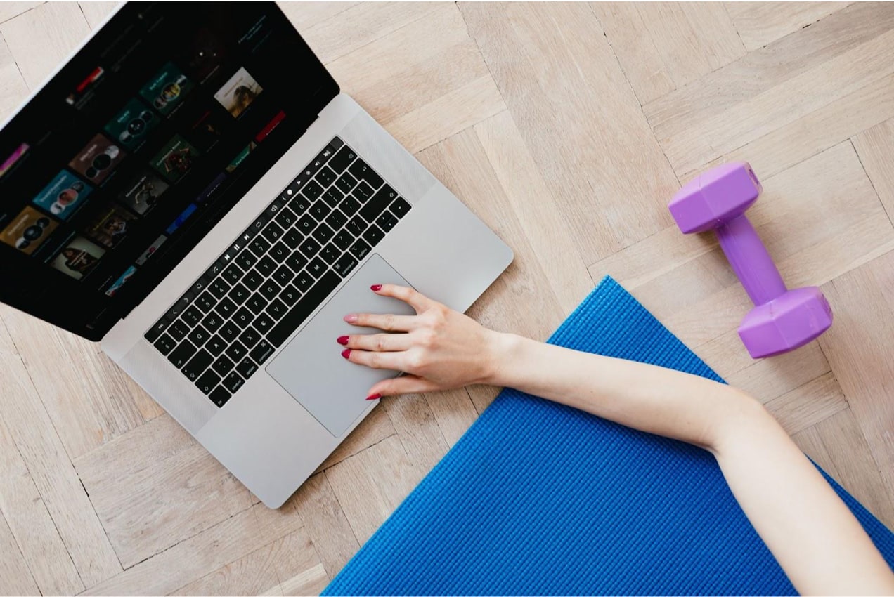 working out on a yoga mat in front of a computer