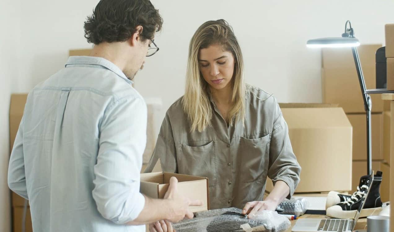 man and woman packing boxes for shipping