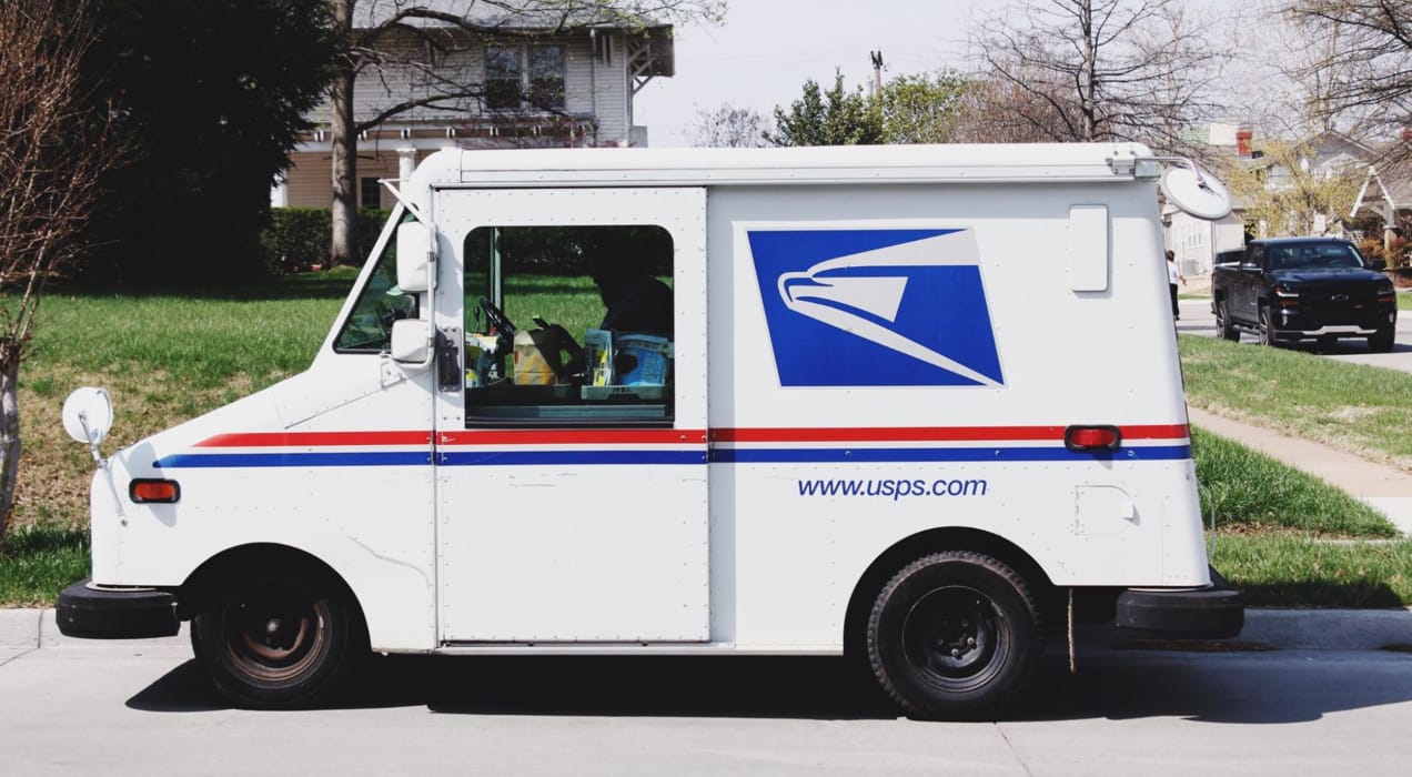 USPS truck in front of a house