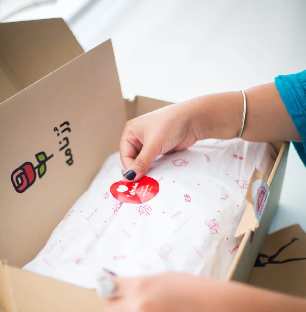 store owner adding a sticker to a shipping box